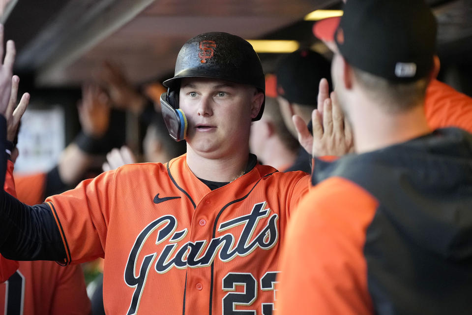 San Francisco Giants' Joc Pederson is congratulated in the dugout after scoring on a double by Michael Conforto against the Arizona Diamondbacks during the third inning of a baseball game in San Francisco, Friday, June 23, 2023. (AP Photo/Tony Avelar)