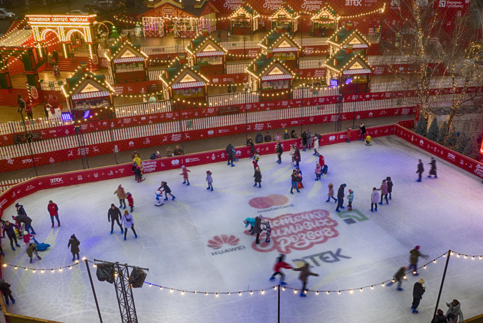 People skate on an ice rink in Kyiv, Ukraine, Wednesday, Dec. 30, 2020. Despite COVID-19 quarantine restrictions, a lot of Ukrainians enjoyed outdoor Christmas events. (AP Photo/Efrem Lukatsky)