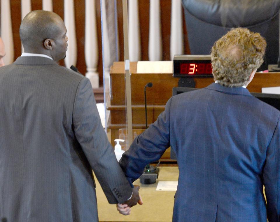 William Hayes Jr. holds the hand of his attorney, Drew Segadelli, right, as the verdict of not guilty in the murder of Darrell Russ is read by the jury foreman in Barnstable Superior Court on Thursday afternoon. Russ died of a gunshot wound in 2019.