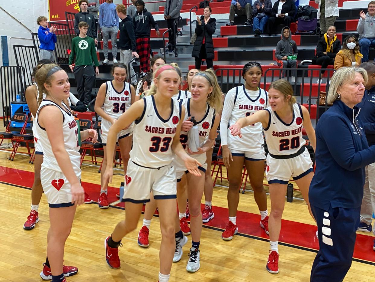 Sacred Heart's girls basketball team celebrates following a 63-50 win over Notre Dame in the Queen of the Commonwealth semifinals at Bullitt East High School on Dec 21. 2021