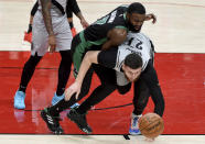 Boston Celtics guard Jaylen Brown, left, and Portland Trail Blazers center Jusuf Nurkic, right, go after a loose ball during the first half of an NBA basketball game in Portland, Ore., Tuesday, April 13, 2021. (AP Photo/Steve Dykes)