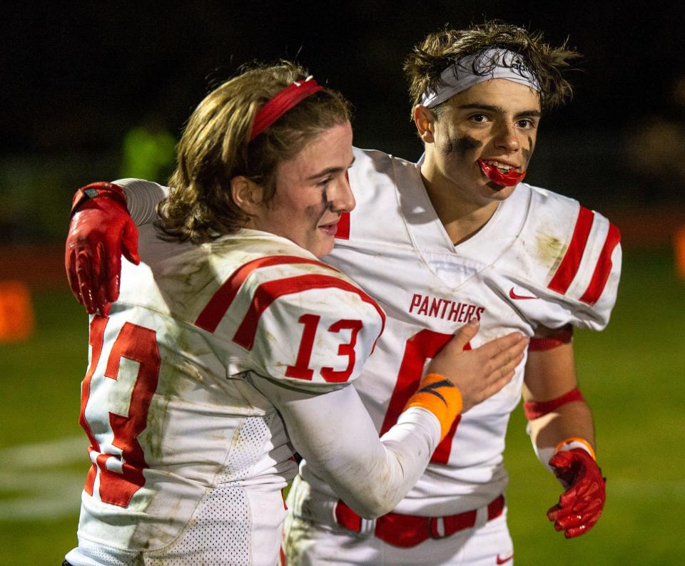 Holliston High School  senior captain quarterback TJ Kiley, left, with senior Andrew Denison after a 21-19 win at Hopkinton, Oct. 28, 2022.