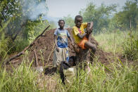A woman, accompanied by children, works on land near to where an unexploded mortar was found, in Moli village, Eastern Equatoria state, in South Sudan Friday, May 12, 2023. As South Sudanese trickle back into the country after a peace deal was signed in 2018 to end a five-year civil war, many are returning to areas riddled with mines left from decades of conflict. (AP Photo/Sam Mednick)