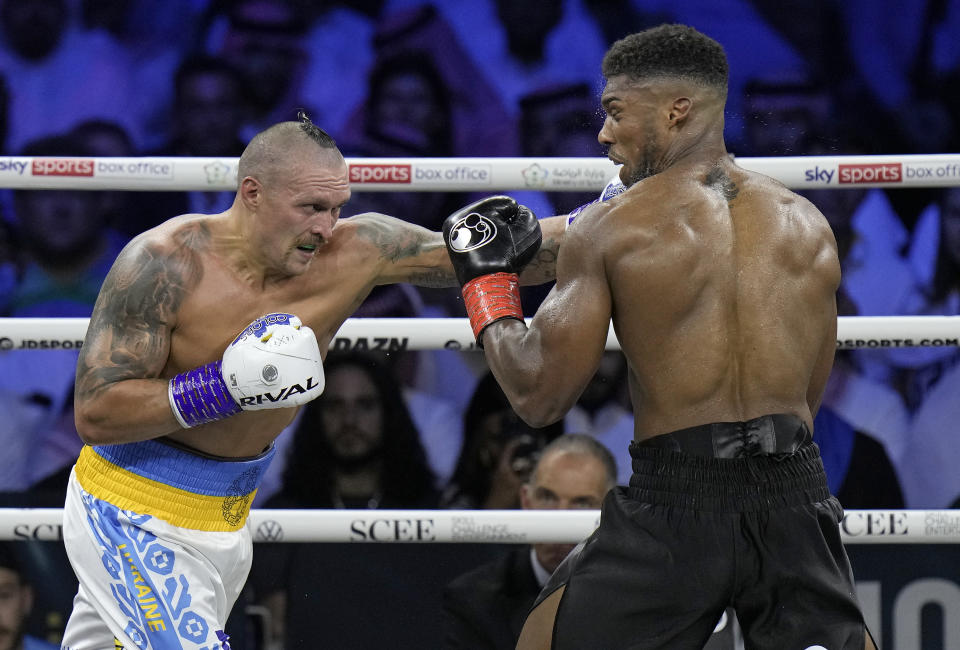 Britain's Anthony Joshua, right, takes a blow from Ukraine's Oleksandr Usyk during their world heavyweight title fight at King Abdullah Sports City in Jeddah, Saudi Arabia, Sunday, Aug. 21, 2022. (AP Photo/Hassan Ammar)