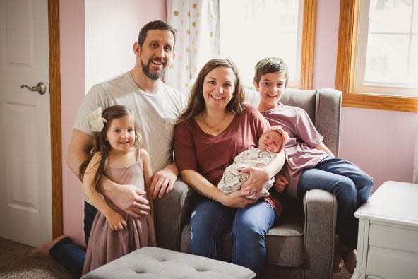 The Bostic family is (left to right) Regan, Brian, Alyssa holding Emryn, and Landon. GLITTER AND GRACE PHOTOGRAPHY
