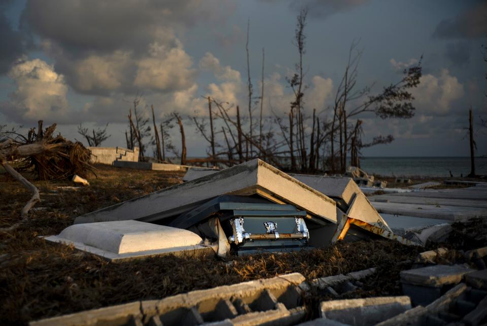 A coffin peaks out of a grave, in aftermath of Hurricane Dorian, at the shattered cemetery in Mclean's Town, Grand Bahama, Bahamas, Wednesday Sept. 11, 2019. Bahamians are tackling a massive clean-up a week after Hurricane Dorian devastated the archipelago’s northern islands. (AP Photo/Ramon Espinosa)