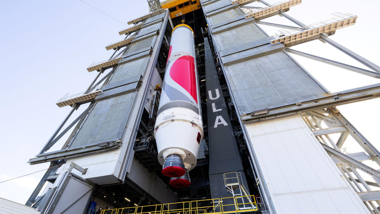  A red-striped rocket is hoisted inside a integration bay. 