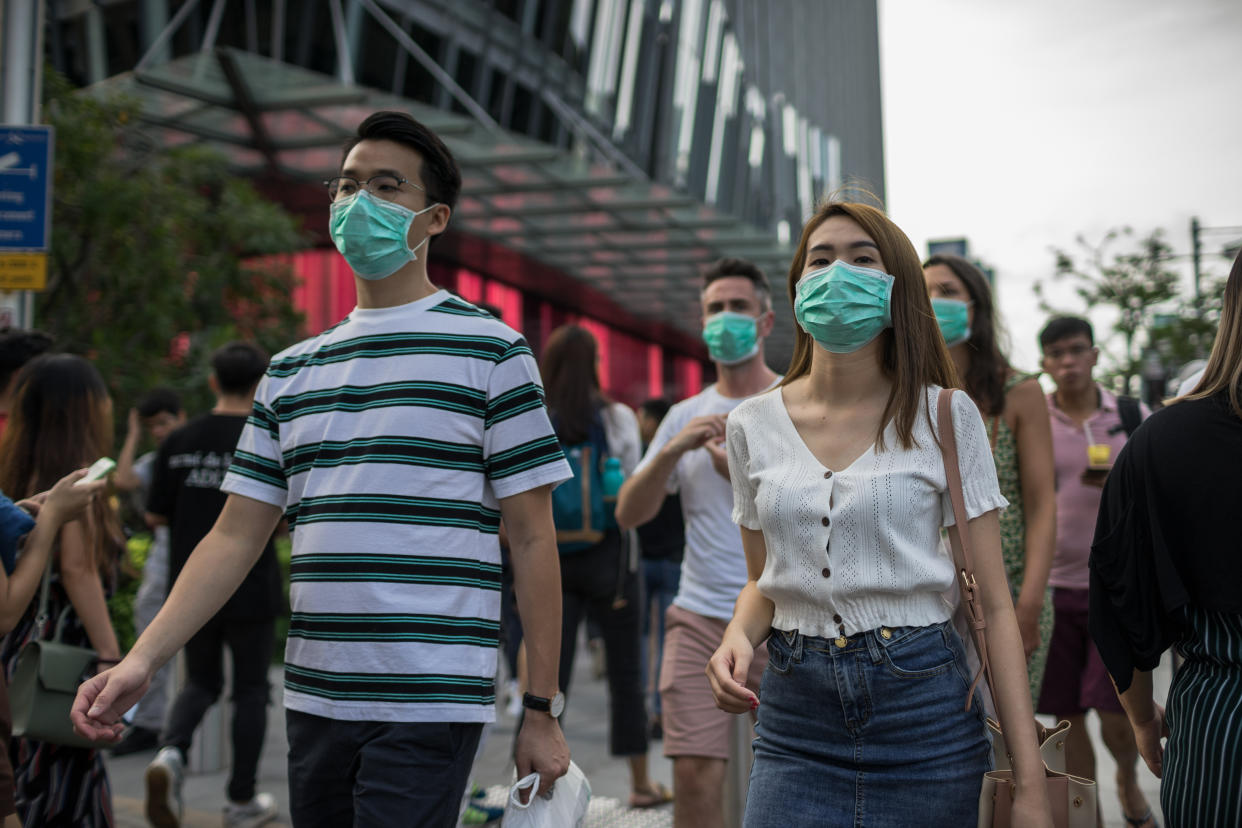 SINGAPORE - 2020/02/14: People wearing protective face masks walks along Orchard Road, a famous shopping district in Singapore, on Valentine's Day. Singapore declared the COVID-19 outbreak as Code Orange on February 7, 2020. (Photo by Maverick Asio/SOPA Images/LightRocket via Getty Images)