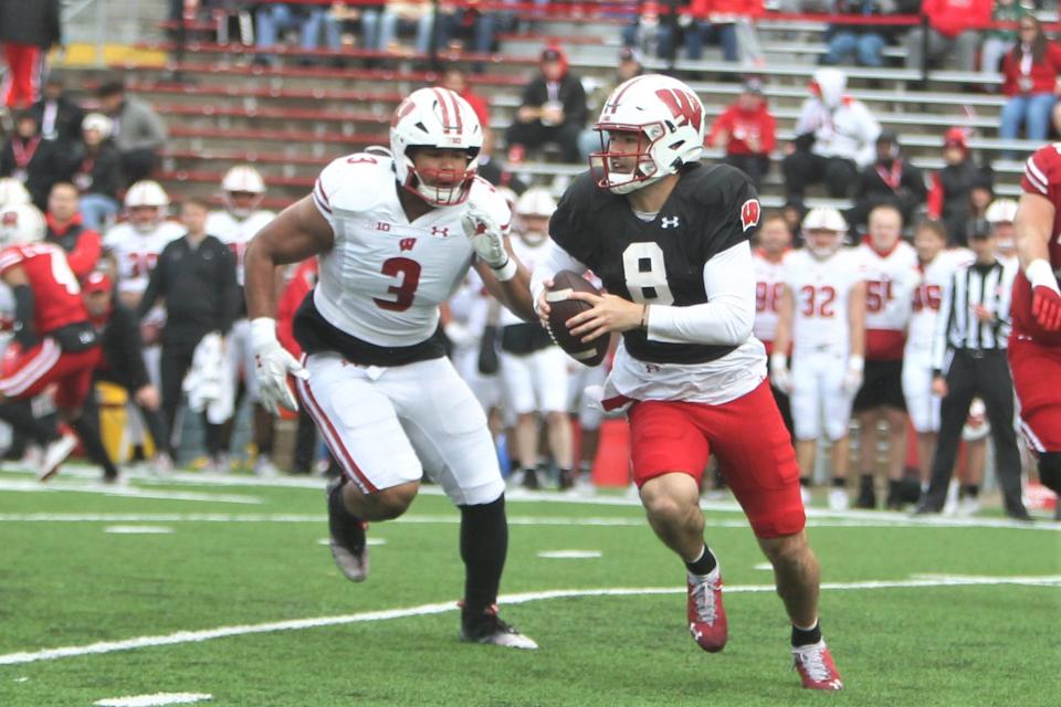 Wisconsin quarterback <a class="link " href="https://sports.yahoo.com/ncaaf/players/292020" data-i13n="sec:content-canvas;subsec:anchor_text;elm:context_link" data-ylk="slk:Tanner Mordecai;sec:content-canvas;subsec:anchor_text;elm:context_link;itc:0">Tanner Mordecai</a> avoids the rush of outside linebacker T.J. Bollers during The Launch, the team’s intra-squad scrimmage at Camp Randall Stadium Saturday April 22, 2023.