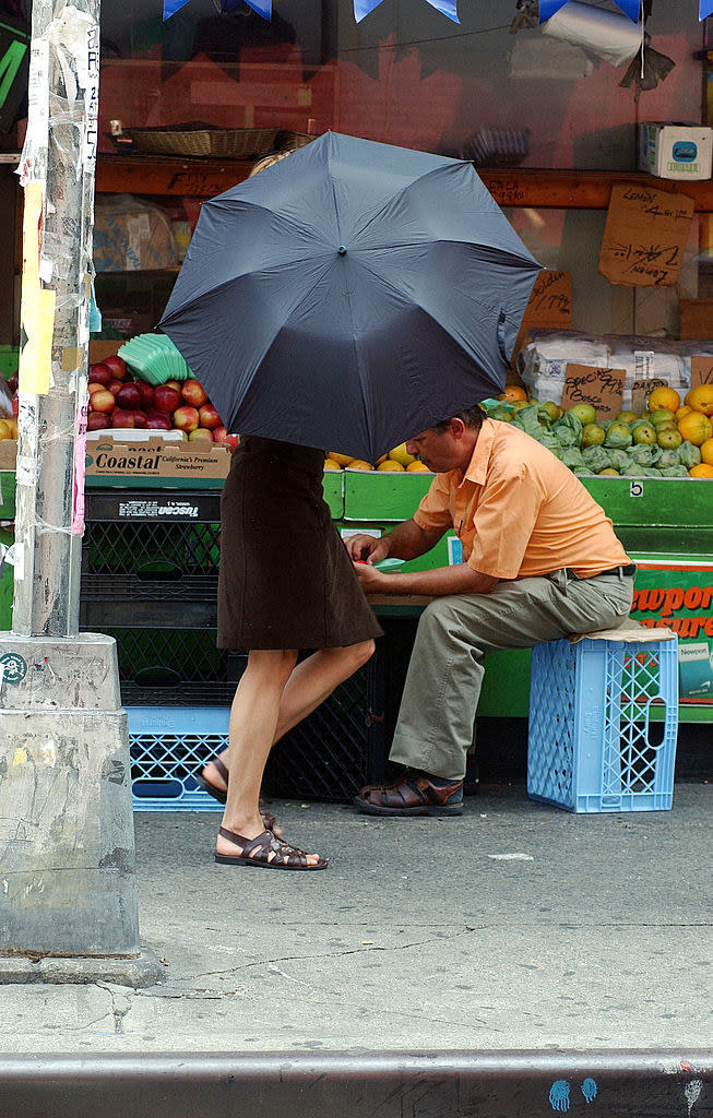 Meg Ryan shielding herself with an umbrella