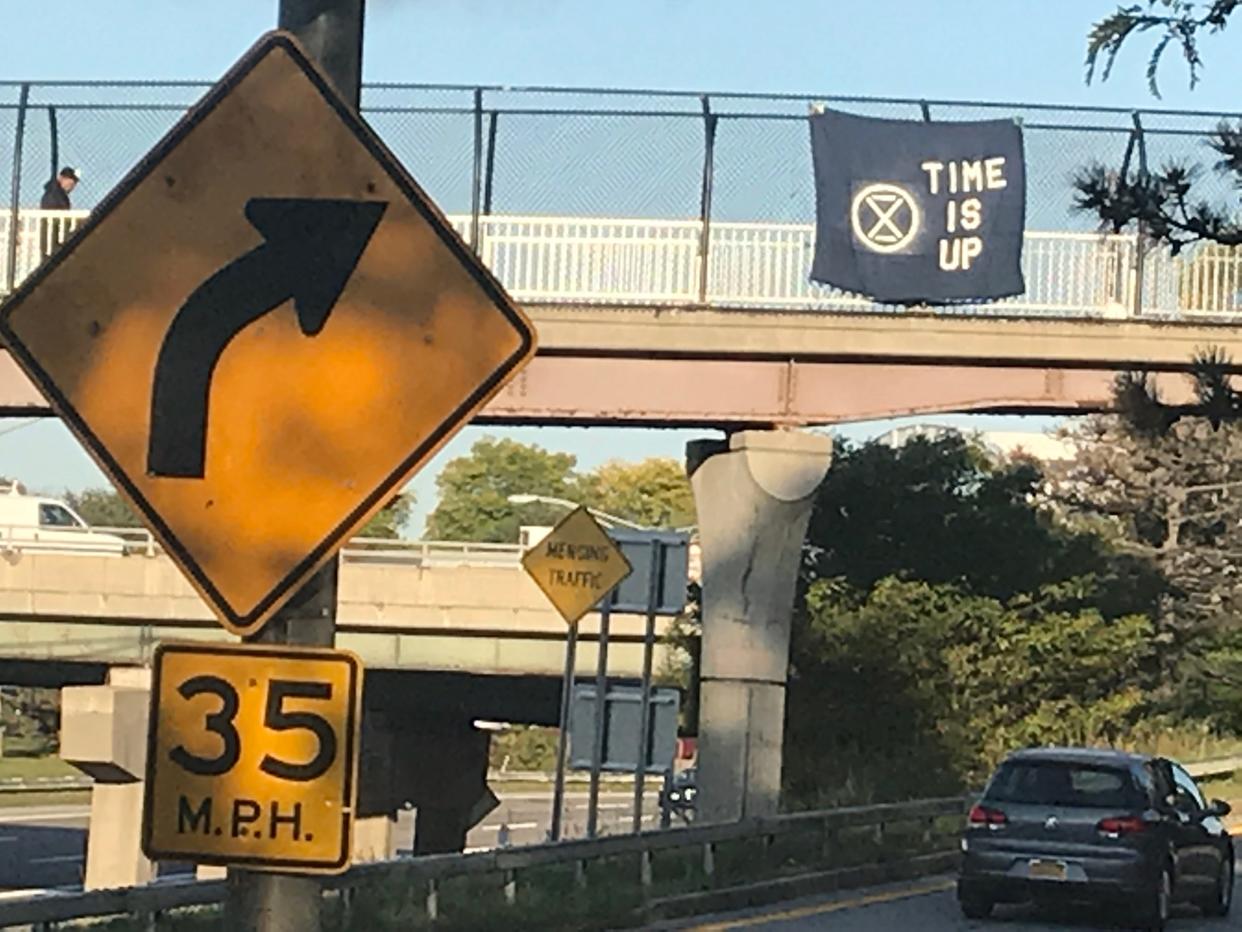A climate-change protest sign hangs above Interstate 490 on Tuesday, Oct. 8, 2019.