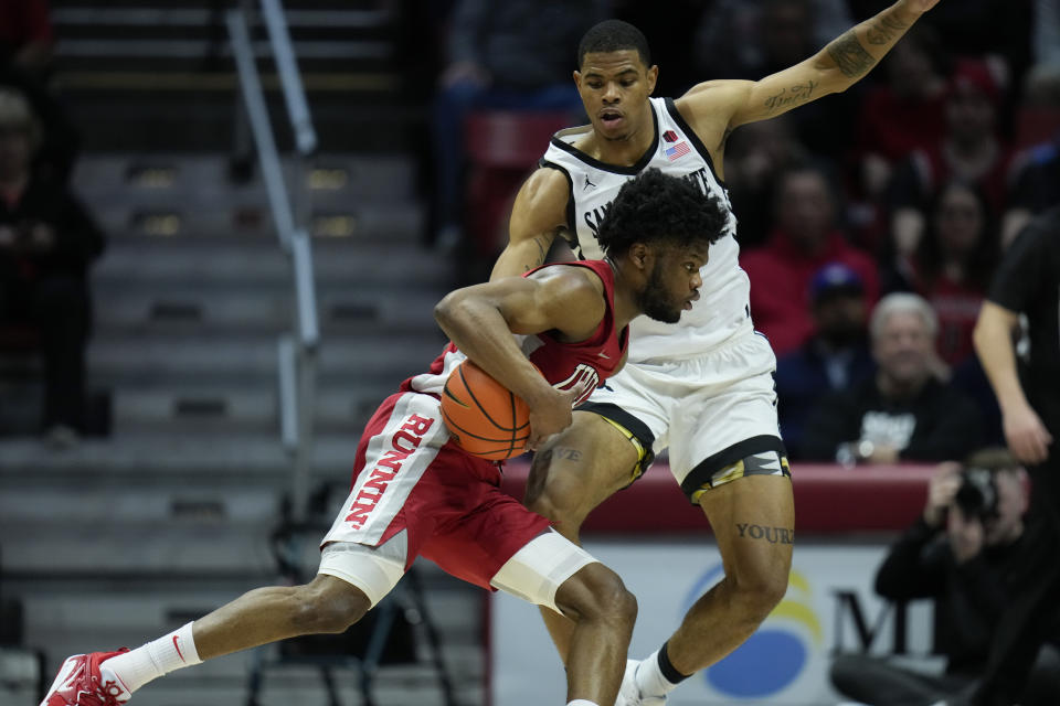 UNLV guard EJ Harkless drives with the ball as San Diego State forward Keshad Johnson defends during the first half of an NCAA college basketball game Saturday, Feb. 11, 2023, in San Diego. (AP Photo/Gregory Bull)