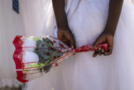 A young girl holds a bunch of flowers behind her back as she awaits the arrival of Pope Francis at the St. Theresa Cathedral in Juba, South Sudan, Saturday, Feb. 4, 2023. Pope Francis is in South Sudan on the second leg of a six-day trip that started in Congo, hoping to bring comfort and encouragement to two countries that have been riven by poverty, conflicts and what he calls a "colonialist mentality" that has exploited Africa for centuries. (AP Photo/Ben Curtis)