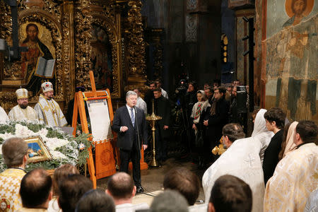 Ukrainian President Petro Poroshenko delivers a speech while standing next to Tomos, a decree granting the Orthodox Church of Ukraine independence, during the Orthodox Christmas service at the Saint Sophia's Cathedral in Kiev, Ukraine January 7, 2019. REUTERS/Valentyn Ogirenko