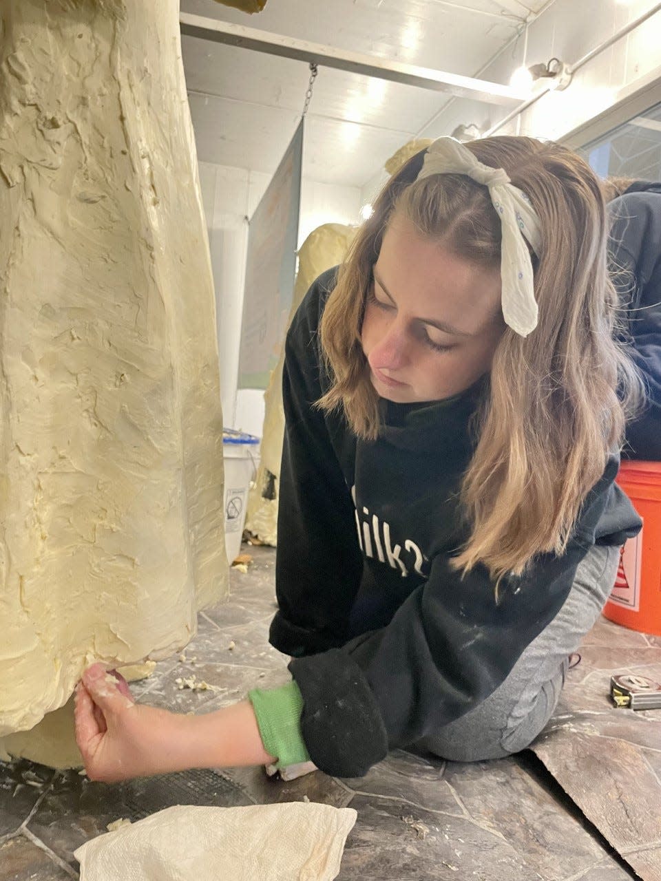 Hannah Pratt works on one of the companion pieces for the butter cow in the Agriculture Building at the Iowa State Fair.