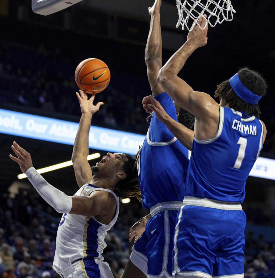 James Madison guard Terrence Edwards (5) takes a shot against Buffalo forward Jonnivius Smith, center, and Buffalo forward Sy Chatman (1) during the first half of an NCAA college basketball game in Harrisonburg, Va., Wednesday, Nov. 29, 2023. (Daniel Lin/Daily News-Record Via AP)