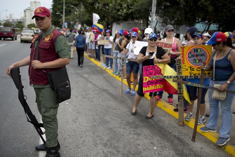 Un guardia nacional vigila a los manifestantes opositores cerca de la playa de La Guaira, Venezuela, el lunes 3 de marzo de 2014. (Foto AP/Rodrigo Abd)