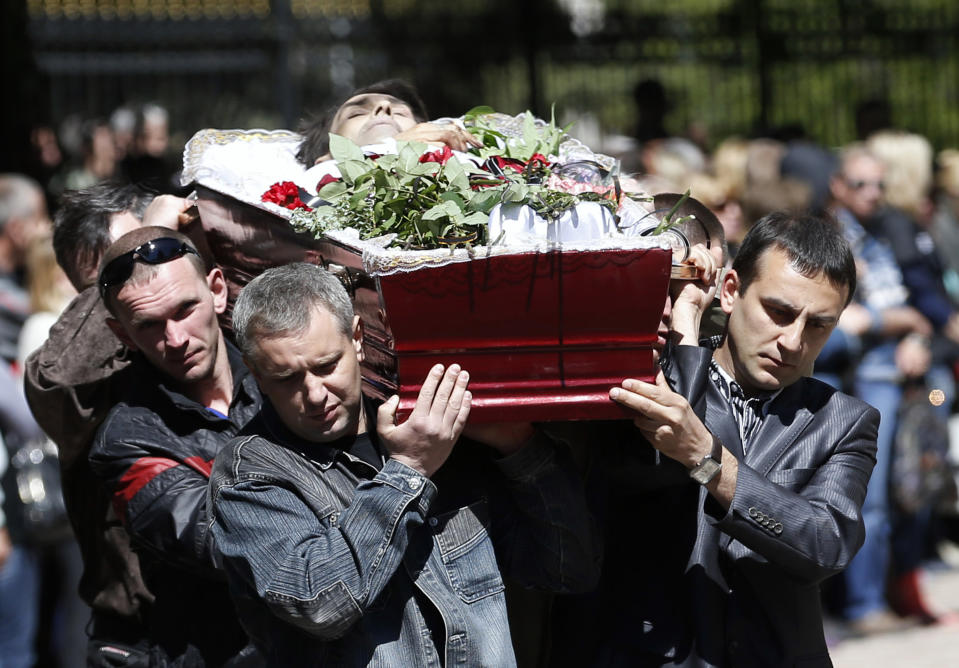 Men carry the coffin of a person killed during last week's unrest, during a commemorative service in the center of Slovyansk, eastern Ukraine, Wednesday, May 7, 2014. The U.S. and European nations have increased diplomatic efforts ahead of Ukraine's May 25 presidential election, as a pro-Russian insurgency continues to rock the country's eastern regions. (AP Photo/Darko Vojinovic)