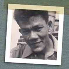 A young British Caribbean man in the 1950s smiling at the camera.