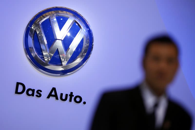 A security guard stand next to a Volkswagen logo at the stage of the company prior to the opening of the 15th Shanghai International Automobile Industry Exhibition in this April 19, 2013 file photograph. REUTERS/Carlos Barria/Files (