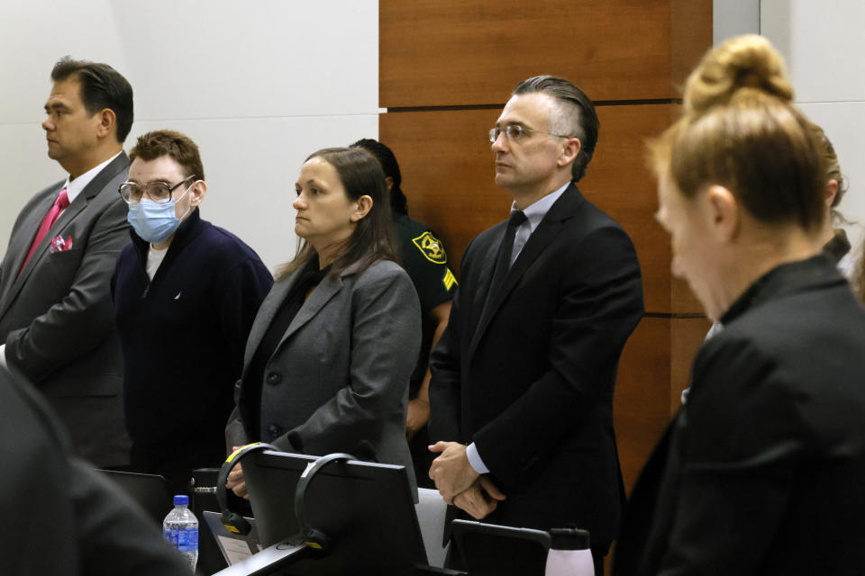 From left, Chief Assistant Public Defender David Wheeler, Nikolas Cruz, sentence mitigation specialist Kate O'Shea, and capital defense attorney Casey Secor stand as the jury enters the courtroom. Nikolas Cruz is in court for the penalty phase of his trial at the Broward County Courthouse in Fort Lauderdale on Thursday, July 21, 2022. Cruz previously plead guilty to all 17 counts of premeditated murder and 17 counts of attempted murder in the 2018 shootings. (Mike Stocker/South Florida Sun Sentinel via AP, Pool)