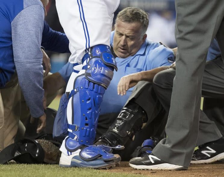 Home plate umpire Dale Scott is attended to on the field after he was hit by a foul tip. (AP)