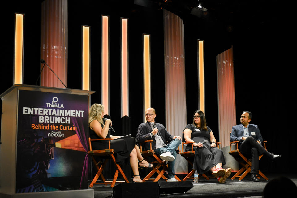 Four panelists sit on a stage at the Beverly Hilton during an entertainment brunch
