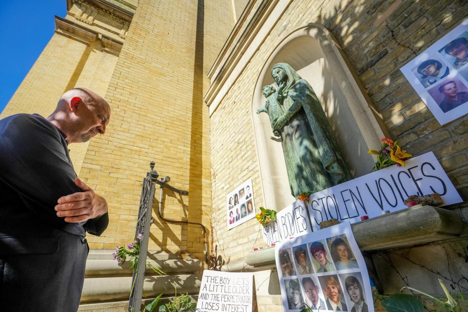 Peter Isley of the anti-clergy abuse group Nate's Mission takes a moment to look over the survivors' memorial which displayed photos, candles, prayer books and more outside of the public funeral for former Archbishop Rembert Weakland Tuesday at the Cathedral of St. John the Evangelist in downtown Milwaukee.