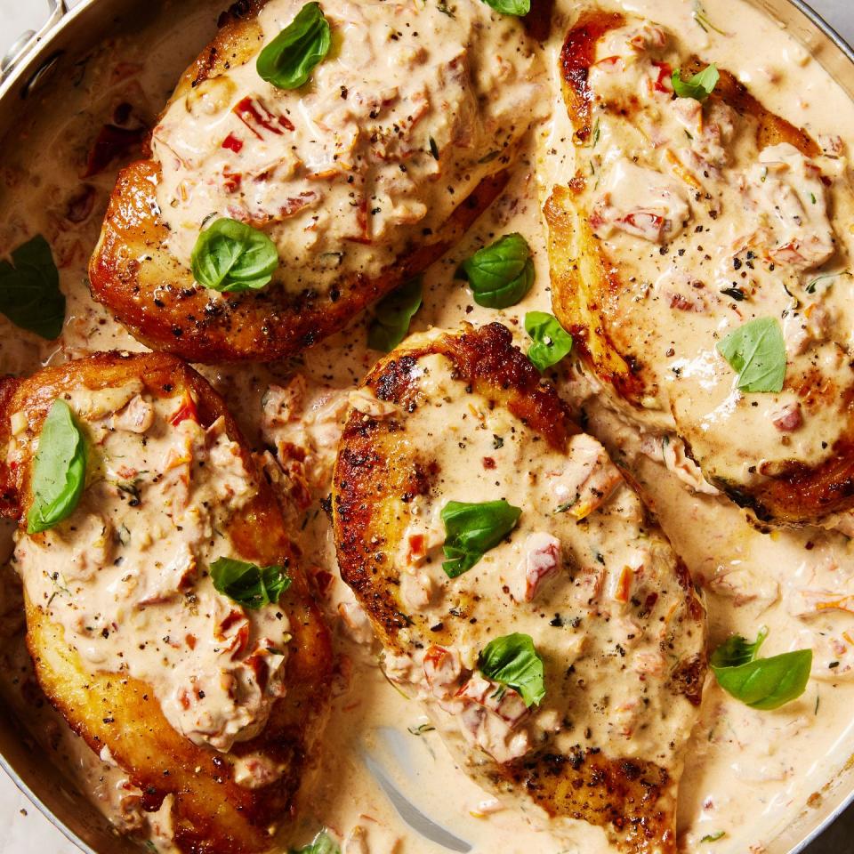 chicken breasts in a skillet with a creamy sun dried tomato sauce