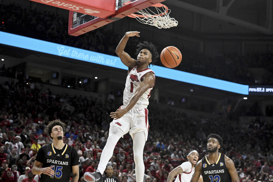 Arkansas guard Ricky Council IV (1) dunks the ball over San Jose State defenders Trey Anderson (15) and Sage Tolbert III (12) during the second half of an NCAA college basketball game Saturday, Dec. 3, 2022, in Fayetteville, Ark. (AP Photo/Michael Woods)