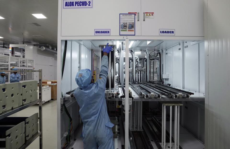 An employee works to unload cell wafers at Premier Energies Solar on the outskirts of Hyderabad, India, Wednesday, Jan. 25, 2023. Solar developers in India fear that a tax meant to encourage Indian manufacture of solar components will slow down the installation of solar power this year. (AP Photo/Mahesh Kumar A.)