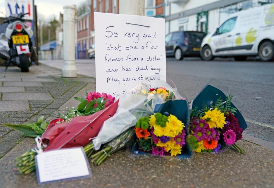 Flowers are left at the entrance at Portland Port in Dorset, following the death of an asylum seeker on board the Bibby Stockholm (PA)