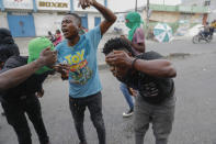 Protesters wipe their faces with water after receiving tear gas fired by police during a protest against Haitian Prime Minister Ariel Henry in Port-au-Prince, Haiti, Monday, Feb. 5, 2024. (AP Photo/Odelyn Joseph)