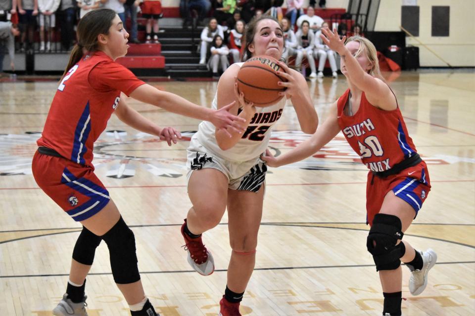 Kenady Hudson splits a pair of South Knox defenders to put up a layup.