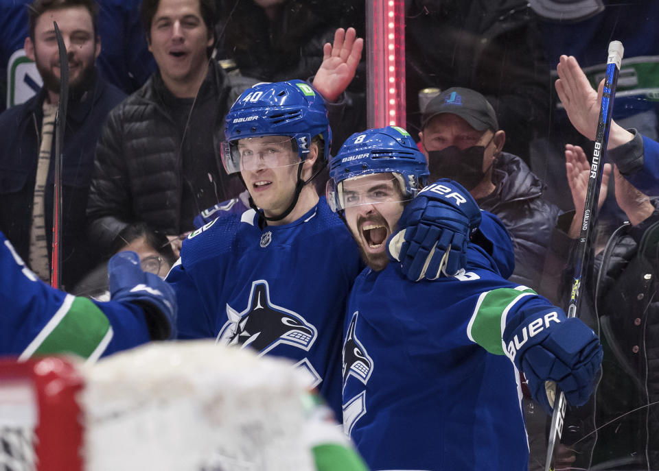 Vancouver Canucks' Conor Garland, right, and Elias Pettersson, of Sweden, celebrate Garland's goal against the Los Angeles Kings during the second period of an NHL hockey game in Vancouver, British Columbia, Monday, Dec. 6, 2021. (Darryl Dyck/The Canadian Press via AP)