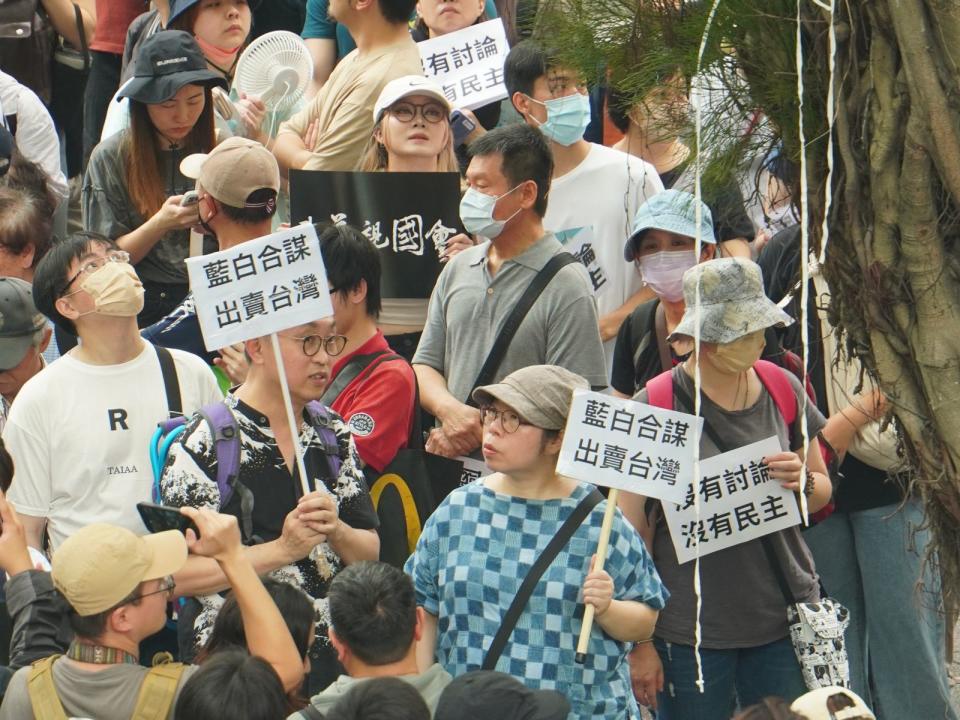 聲援民眾高舉抗議手舉牌。林泊志攝