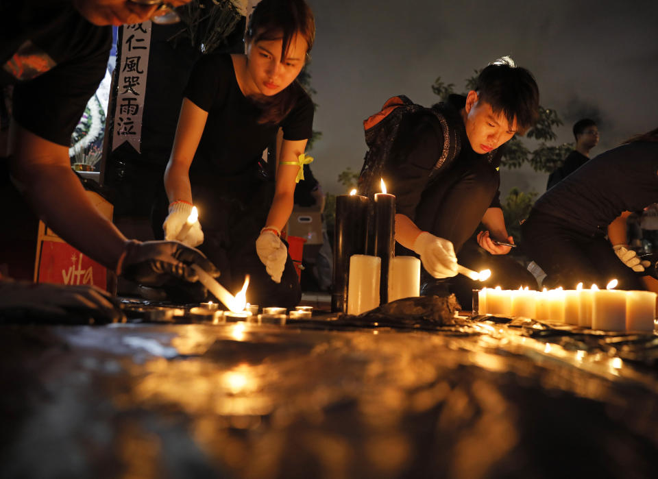 People light candles during a vigil to mourn the recent suicide of a woman due to the government's policy on the extradition bill, in Hong Kong Saturday, July 6, 2019. A vigil is being held in Hong Kong for a woman who fell to her death this week, one of three apparent suicides linked to ongoing protests over fears that freedoms are being eroded in this semi-autonomous Chinese territory. (AP Photo/Vincent Yu)