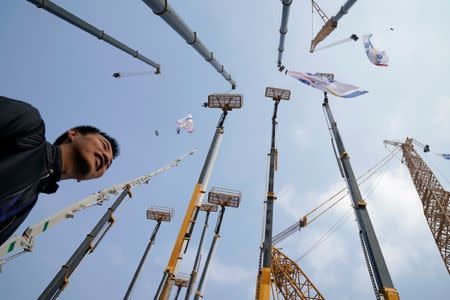 FILE PHOTO: A man visits heavy machinery at Bauma China, the International Trade Fair for Construction Machinery in Shanghai, China November 27, 2018. REUTERS/Aly Song