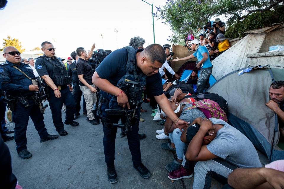 Policía municipal de Ciudad Juárez pide desalojar a migrantes de un área donde habían acampado frente a las instalaciones donde 40 migrantes murieron en un incendio en una estancia migratoria el 27 de marzo de 2023.