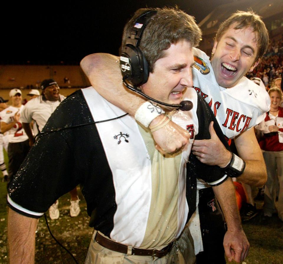 Texas Tech quarterback Kliff Kingsbury celebrates with head coach Mike Leach in the final minutes of the fourth quarter against Clemson at the Mazda Tangerine Bowl on Monday, Dec. 23, 2002, in Orlando, Fla.