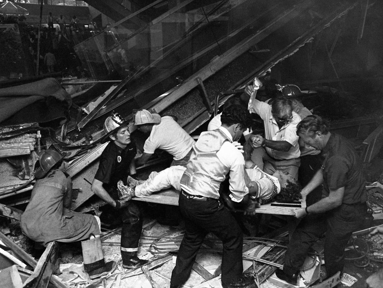 Firefighters rescue people from under a collapsed walkway in the Kansas City Hyatt Regency hotel in 1981 (Bettman Archive via Getty)