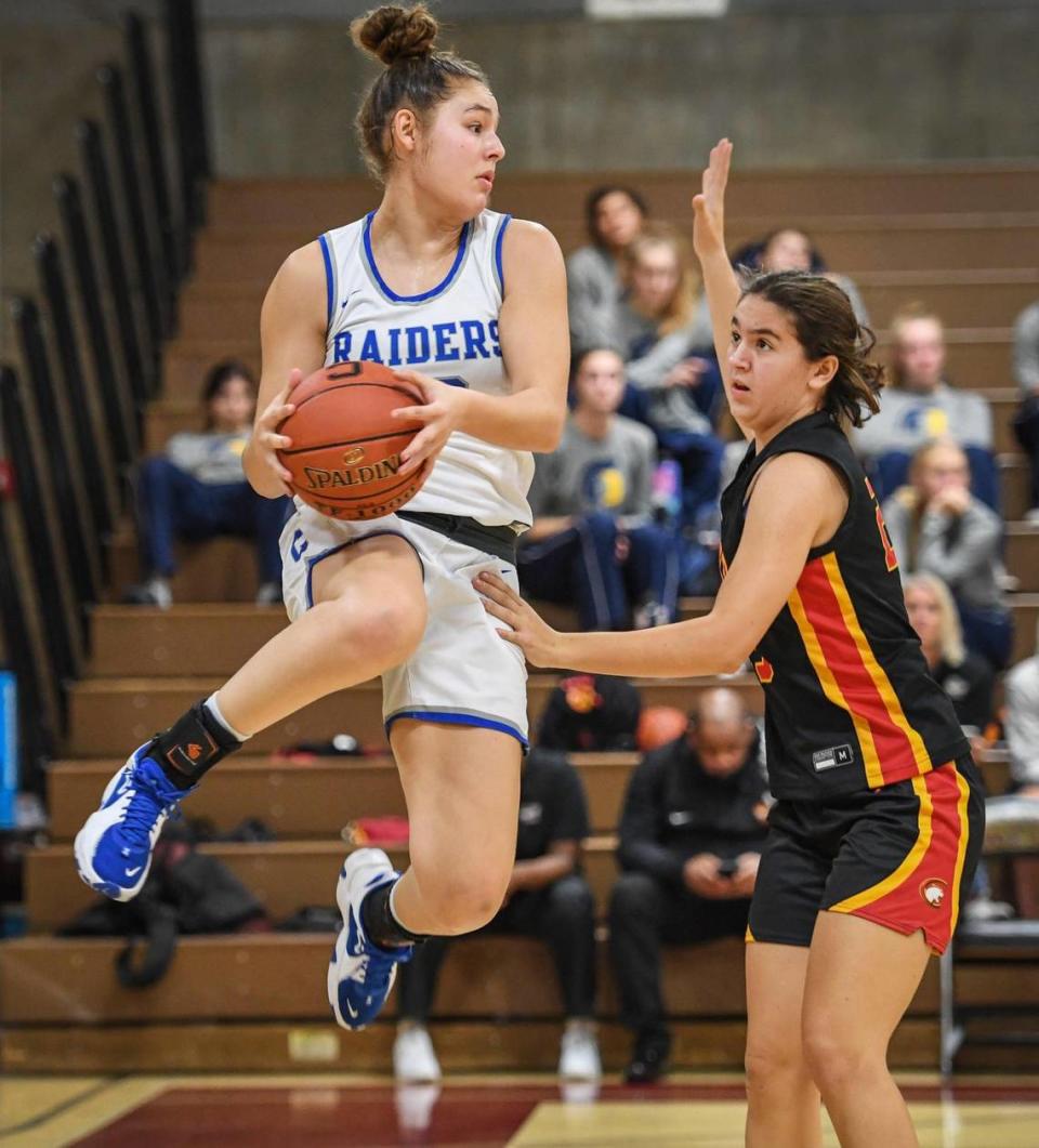 Caruthers’ Krissy Turman, left, leaps for the ball while trying to keep it in bounds as Chico High’s Maddelena Cavina defends during their game in the annual Nike Central Valley Showdown girls basketball tournament at Clovis West High School on Friday, Dec. 3, 2021.