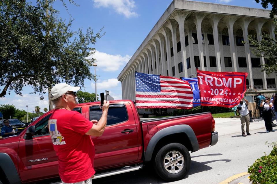 A vehicle with flags in support of Donald Trump drives outside of the Paul G. Rogers Federal Courthouse, Thursday, Aug. 18, 2022, in West Palm Beach, Fla (AP)