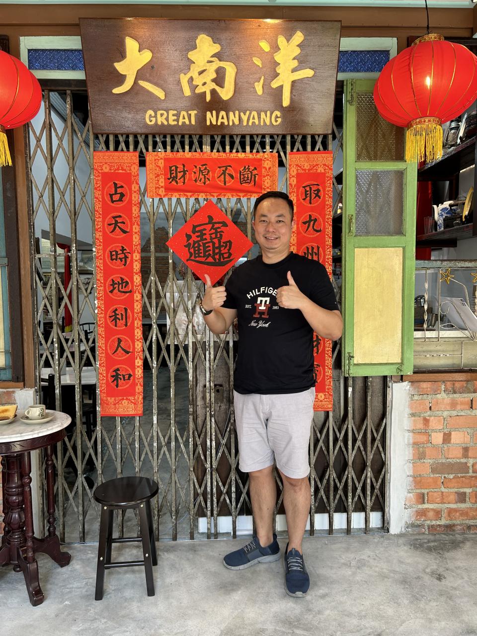 Keith Kang poses in front of his new cafe, Great Nanyang.