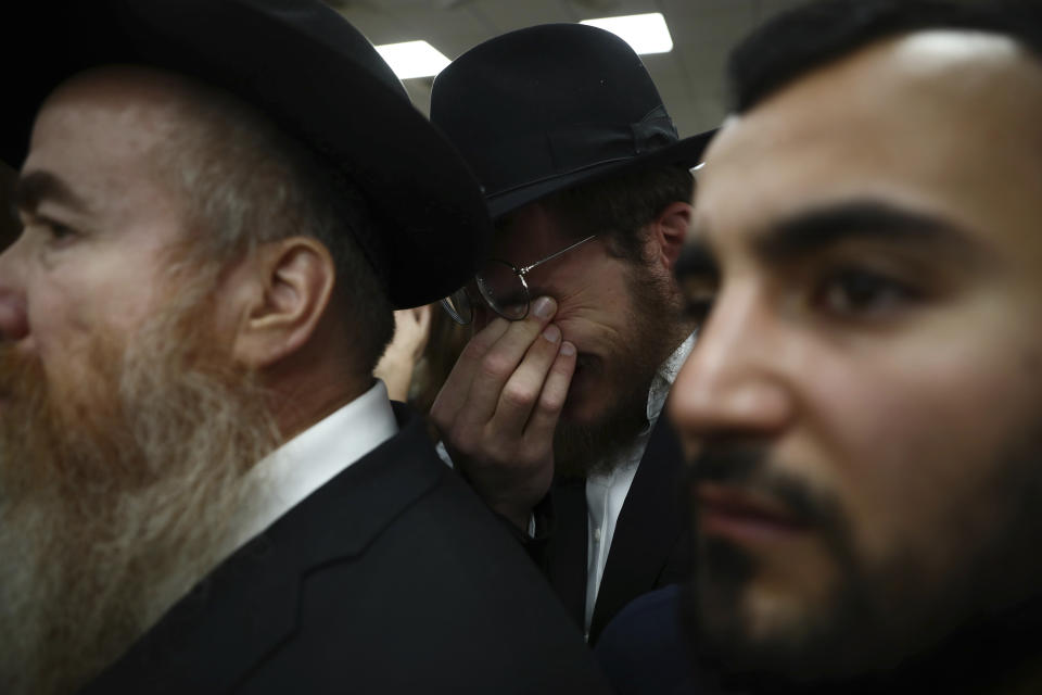 A mourner weeps during the funeral for Eliyahu Kay, a 26-year-old immigrant to Israel from South Africa, the day after he was killed when a Palestinian man opened fire in the Old City of Jerusalem, Monday, Nov. 22, 2021, in Jerusalem. (AP Photo/Oded Balilty)