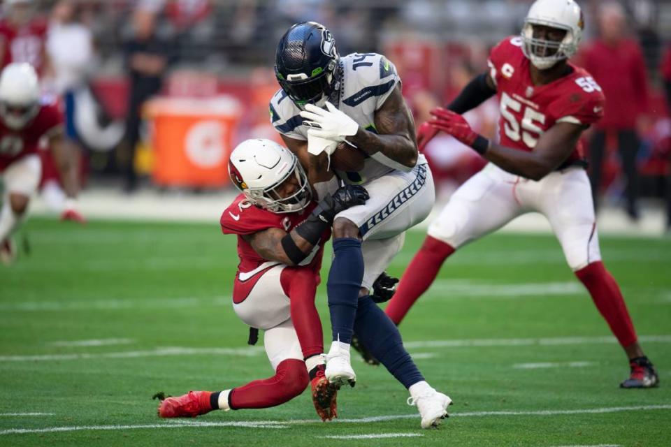 Arizona Cardinals safety Budda Baker (3) tackles Seattle Seahawks wide receiver DK Metcalf (14) in the first half during an NFL Professional Football Game Sunday, Jan. 9, 2022, in Phoenix. (AP Photo/John McCoy)