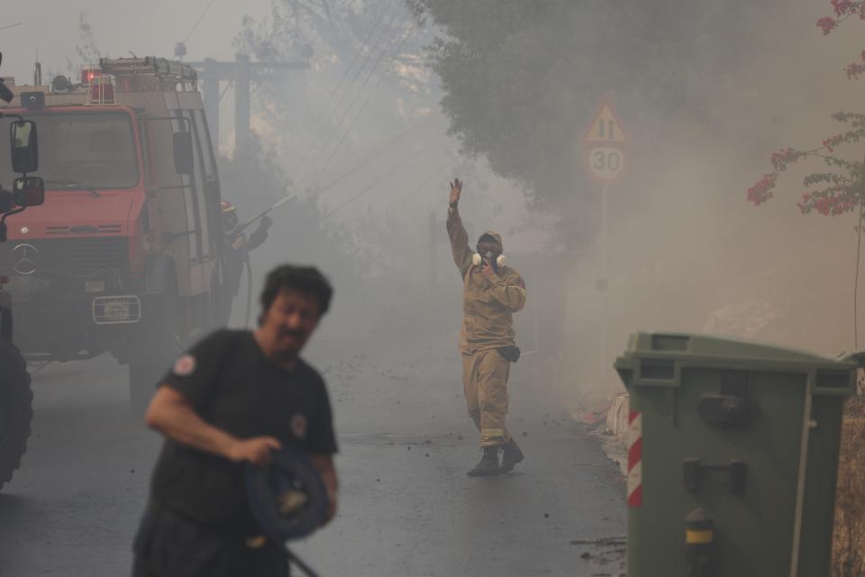 Firefighters operate during a wildfire in Voula suburb, in southern Athens, Greece, Saturday, June 4, 2022. A combination of hot, dry weather and strong winds makes Greece vulnerable to wildfire outbreaks every summer. (AP Photo/Yorgos Karahalis)