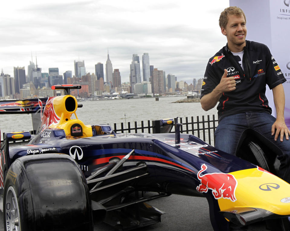 Defending Formula One champion Sebastian Vettel, of Germany, poses Monday, June 11, 2012 in Weehawken, N.J. Vettel drove a 3.2-mile course to demonstrate the planned route for next year's Grand Prix of America race. Auto racing officials and Gov. Chris Christie in 2011 announced a 10-year agreement with the F1 series. In the background is the Manhattan. (AP Photo/Julio Cortez)