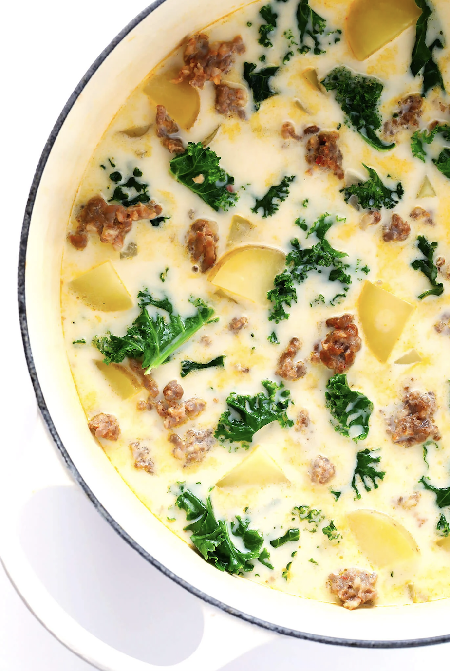 A pot of soup with sausage, kale, and potatoes