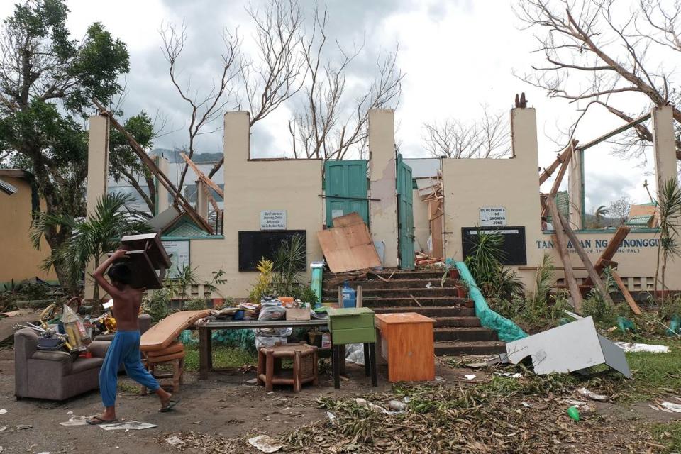 A resident salvages personal belongings in 2020 after Typhoon Goni destroyed his home in the Philippines.